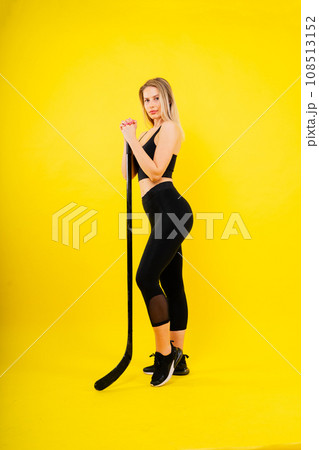 Ice hockey fan female in sports wear with hockey stick in studio Ice hockey fan female in sports wear with hockey stick in studio 108513152