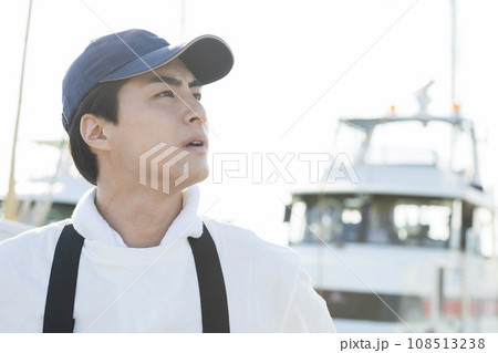 漁港に立つ若い漁業従事者 108513238