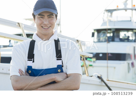 漁港に立つ若い漁業従事者 108513239