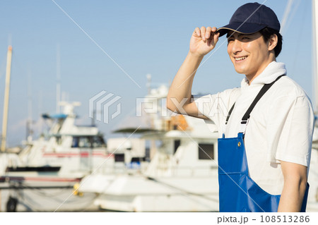 漁港に立つ若い漁業従事者 108513286