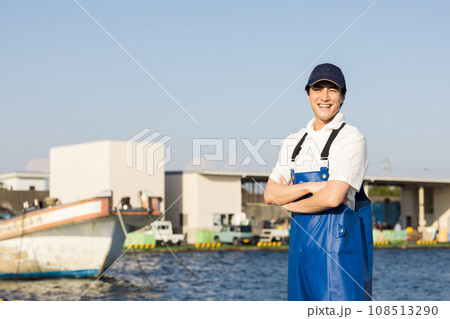 漁港に立つ若い漁業従事者 108513290