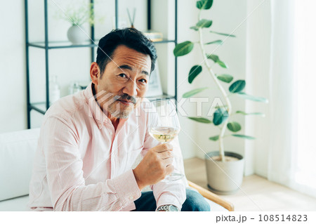 自宅で白ワインを飲むミドルの男性 自宅で白ワインを飲むミドルの男性 108514823