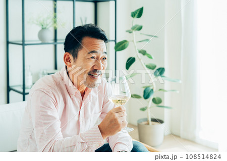 自宅で白ワインを飲むミドルの男性 108514824
