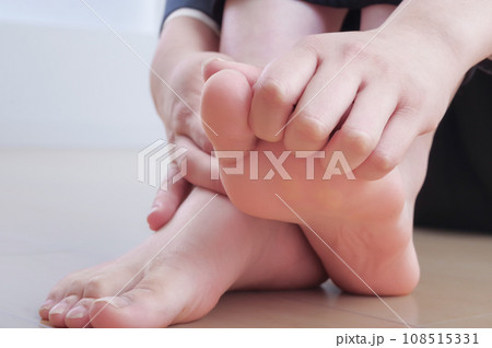 足の指先を触っている若い女性 足の指先を触っている若い女性 108515331