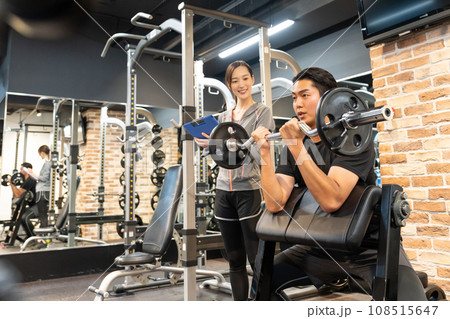 パーソナルトレーナーの女性と筋トレをする男性 パーソナルトレーナーの女性と筋トレをする男性 108515647