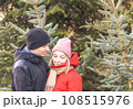 Portrait of happy woman and man hugging at Christmas Market in front of Christmas tree. 108515976