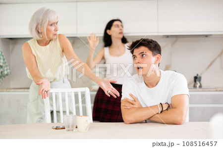 Elderly woman mother and young girl during family quarrel accuse adult son 108516457
