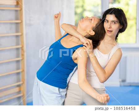 Two women training self-defense techniques in studio 108516458