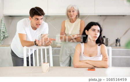 Sad woman dont speaking after discord with mother and husband standing behind 108516459