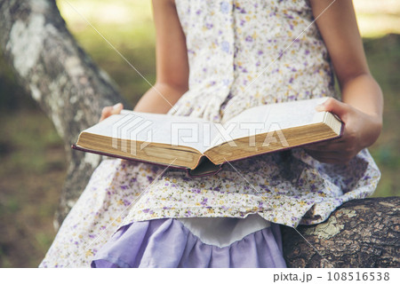 Asian Girl holding book reading at green park in natural garden. Young todler girl relaxation read open book self study. Happy child women smiling with happiness learning. Kid sit in green park Asian Girl holding book reading at green park in natural garden. Young todler girl relaxation read open book self study. Happy child women smiling with happiness learning. Kid sit in green park 108516538