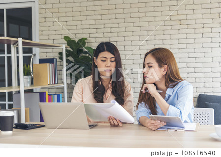 Happy success business woman partner working together in company office corporate executive teamwork. Meeting Executive Asian business woman using laptop office desk with fist arm raised win happiness 108516540