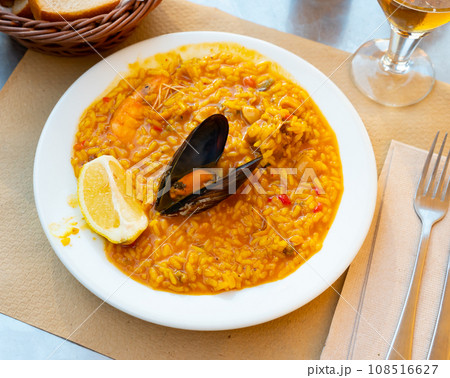 Valencian seafood paella - savory rice dish with shrimps, clams and chicken Valencian seafood paella - savory rice dish with shrimps, clams and chicken 108516627