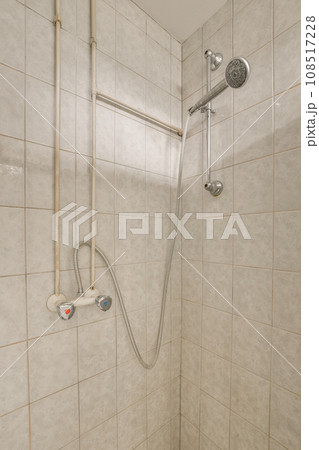 a shower that is in someone's bathroom with white tiles on the walls and tile around the shower head a shower that is in someone's bathroom with white tiles on the walls and tile around the shower head 108517228