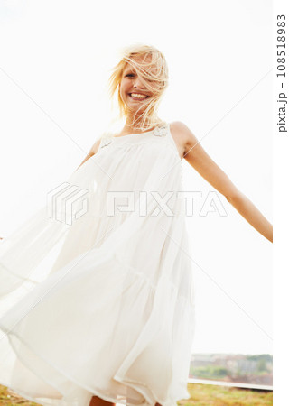 Portrait, happy woman and dress in wind outdoor on vacation, holiday or travel in summer. Freedom, smile and confident blonde person standing in nature, garden or countryside with sky in Amsterdam 108518983