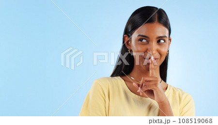 Secret, gossip and woman with finger on lips, smile and announcement on a blue background. Person, girl and model with privacy, mockup space and drama news with surprise, emoji and whisper with shush 108519068