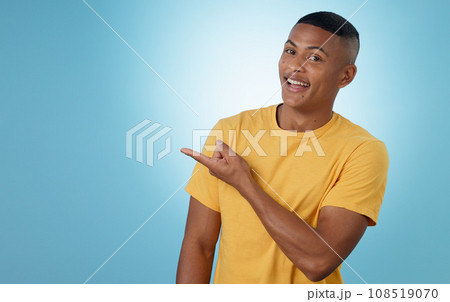 Man, student pointing and presentation for education, learning or college news and information in studio. Portrait of a young person with university guide, advice and mockup on a blue background 108519070