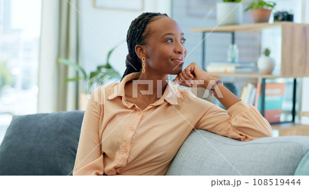 African woman, sofa and thinking in home living room with smile, memory or decision with vision. Person, relax and happy on lounge couch with ideas, solution and problem solving with brainstorming 108519444