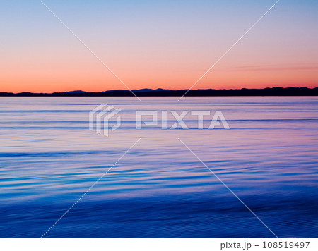 Sunset on horizon, water and lake outdoor, sky and mockup space in Mediterranean coastline reflection. Sea, ocean and sunrise at seascape at dawn in the morning in nature, calm scenery and summer 108519497