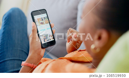 Hands, phone and food order with a black woman on a sofa to relax in the living room of her home. Mobile, screen or display with an online customer searching for a luxury product on a meal website 108519930