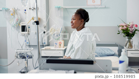 Patient, hospital and happy on bed with recovery, illness and accept diagnosis with treatment plan. Black woman, healthcare and wellness in medical center, bedroom and smiling for doctor and therapy 108519985