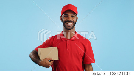 Happy man, box and delivery in transport service, package or order in studio against a blue background. Portrait of male person or courier guy smile with parcel, cargo or logistics on mockup space 108521135