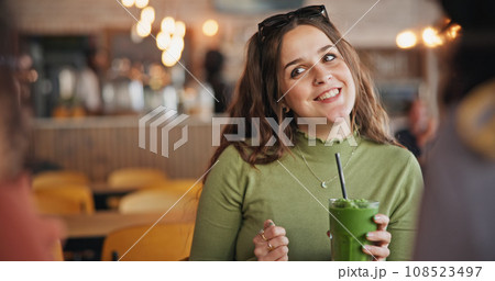 Girl friends, talk and smoothie in cafe, green drink and happy for health, nutrition and juice with smile. Gen z woman, milkshake or diet with group, students and chat in restaurant, diner and cafe 108523497
