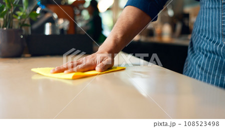 Waiter, hands and cleaning table in coffee shop for dust, bacteria and dirt with cloth, spray or detergent. Barista, person and wipe wooden furniture in cafe or restaurant for shine or professional Waiter, hands and cleaning table in coffee shop for dust, bacteria and dirt with cloth, spray or detergent. Barista, person and wipe wooden furniture in cafe or restaurant for shine or professional 108523498