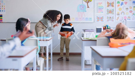 Teacher, child and reading a book in class for learning, development and communication. A boy kid or student and woman teaching language, support and assessment in elementary classroom at school 108525182