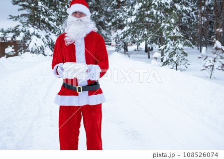 Food delivery service containers in hands of Santa Claus outdoor in snow. Christmas eve promotion. Ready-made hot order, disposable plastic box. New year holidays catering. Copy space, mock up Food delivery service containers in hands of Santa Claus outdoor in snow. Christmas eve promotion. Ready-made hot order, disposable plastic box. New year holidays catering. Copy space, mock up 108526074