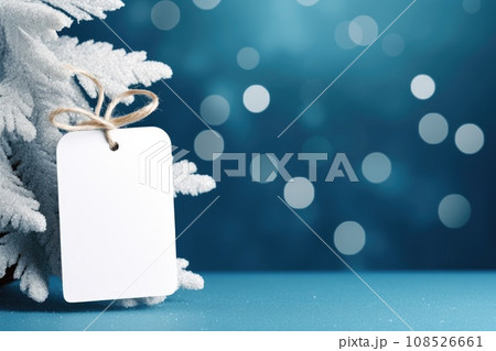 White blank price tag on blue background with Christmas tree branch. Copy space. 108526661