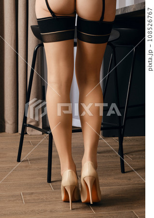 Rear view of female legs in stockings with garter belt 108526767