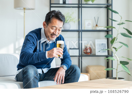 リビングでビールを飲むミドルの男性 108526790