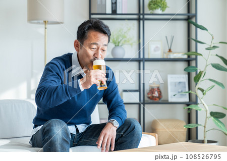 リビングでビールを飲むミドルの男性 108526795