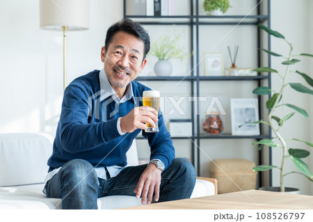 リビングでビールを飲むミドルの男性 リビングでビールを飲むミドルの男性 108526797