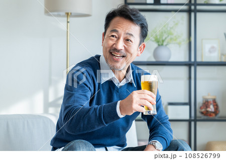 リビングでビールを飲むミドルの男性 108526799