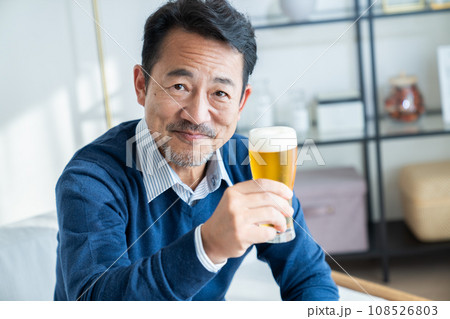 リビングでビールを飲むミドルの男性 108526803