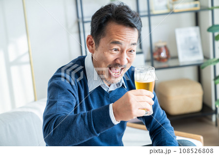 リビングでビールを飲むミドルの男性 108526808