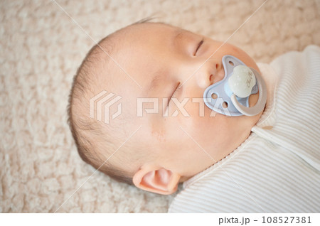 おしゃぶりを吸って寝る赤ちゃん 108527381