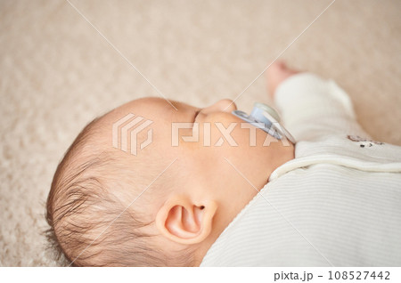 おしゃぶりを吸って寝る赤ちゃん おしゃぶりを吸って寝る赤ちゃん 108527442