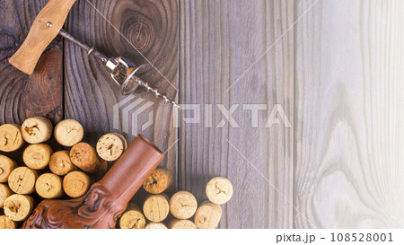 Bottle of wine with corks on wooden table background. on soft sunlight 108528001