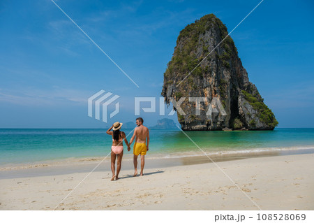 A couple of men and woman walking on the beach of Railay Beach Krabi Thailand 108528069
