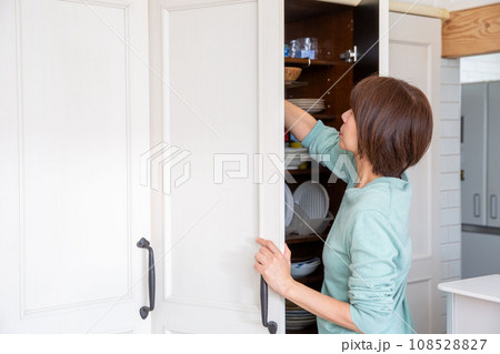 食器棚の収納に悩む女性、後ろ姿 108528827