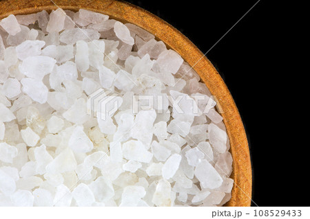 White bath salt in a wooden bowl closeup isolated on black background White bath salt in a wooden bowl closeup isolated on black background 108529433