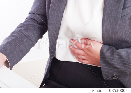 下腹部が痛そうに手を当てている女性 108530005