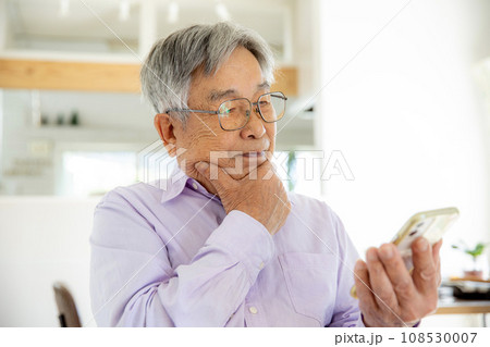 スマホの操作に悩む日本人シニア男性 108530007