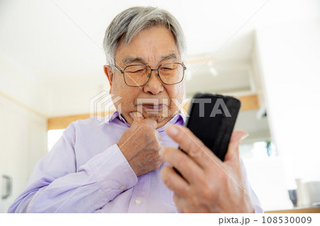 スマホの操作に悩む日本人シニア男性 108530009
