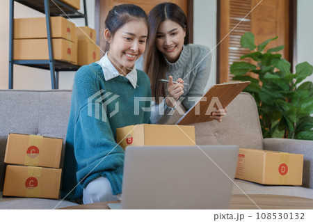 Starting small business entrepreneur of independent young Asian woman online seller is using computer and taking orders to pack products for delivery to customers. SME delivery concept. 108530132