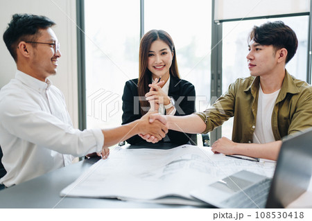 Engineers, designers and interior designers are handshake shack hands deal finalizing the design of interiors by discussing selecting materials and colors to design rooms to present to clients 108530418