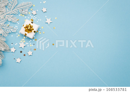 Christmas gift box with decorations and sparkles on blue bacground. 108533781