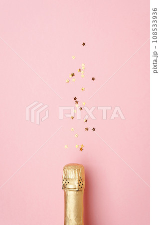Champagne bottle with confetti stars on color background, space for text Champagne bottle with confetti stars on color background, space for text 108533936